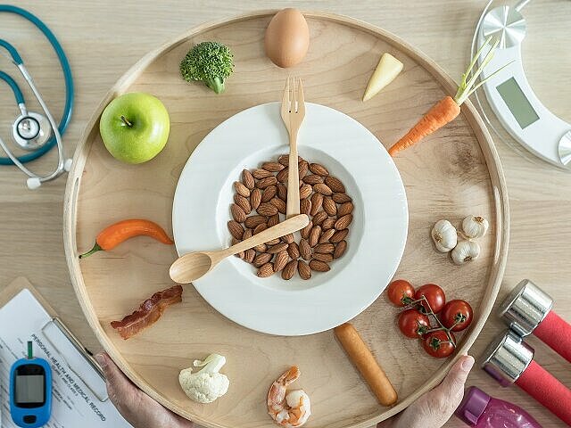Uhr mit verschiedenen Lebensmitteln anstelle von Zahlen symbolisiert die Regeln des Glukose-Tricks