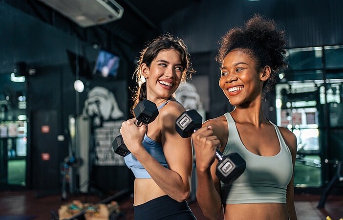 zwei-frauen-machen-kraftsport-im-fitnessstudio-um-stoffwechsel-anzuregen