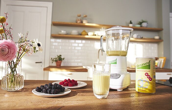 Almased-shake-fuer-stoffwechsel-mit-mixer-und-beeren-im-hintergrund