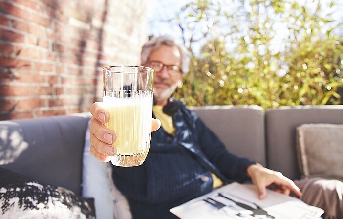 Mann mit Glas Almased in der Hand