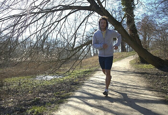 Protein-Shake-sportlicher-Mann-laeuft-im-Wald