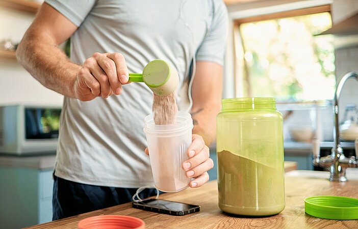 Mann-bereitet-Proteinshake-zum-Abnehmen-mit-Proteinppulver-zu