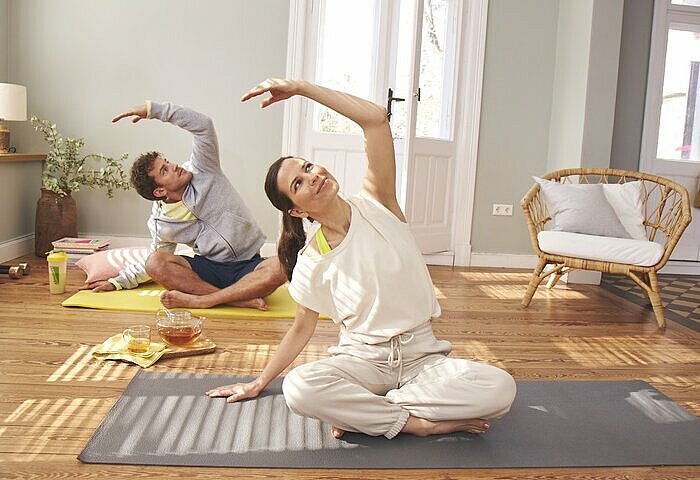 Mann und Frau machen Yoga um Stoffwechsel zu boosten