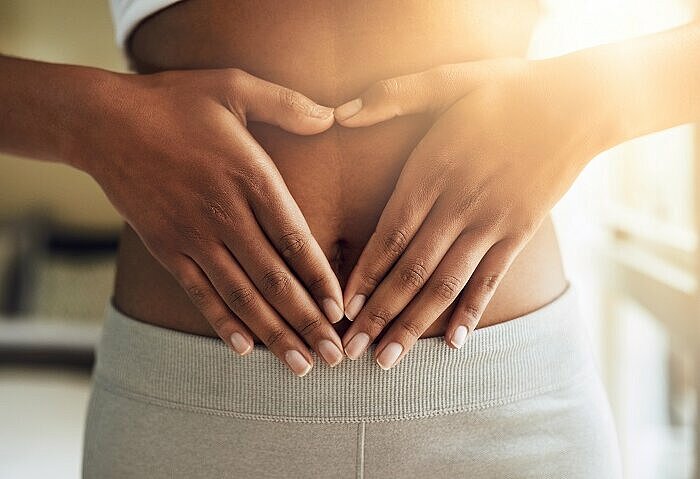 Frau-hält-Hände-auf-Bauch-um-Sättigung-durch-Proteinshakes-darzustellen