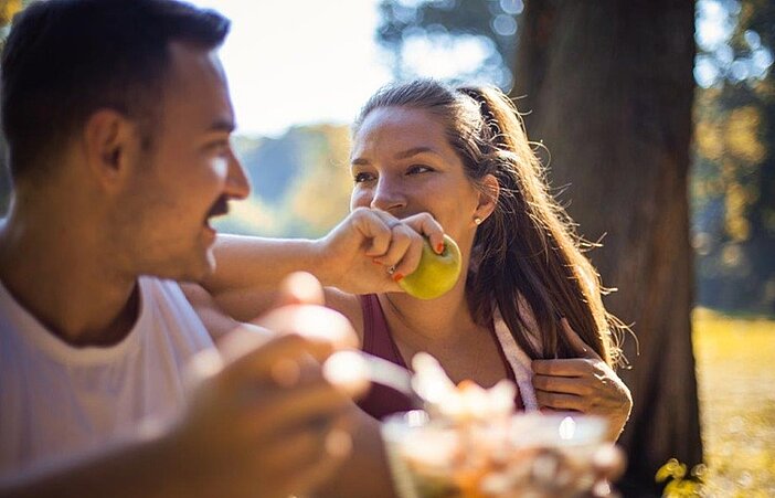 Paar-isst-Apfel-in-Park-um-Stoffwechsel-anzuregen